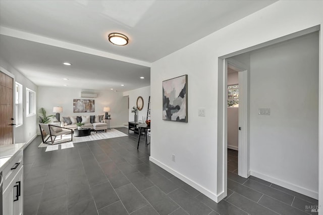 hall with dark tile patterned floors, recessed lighting, baseboards, and a wall mounted air conditioner