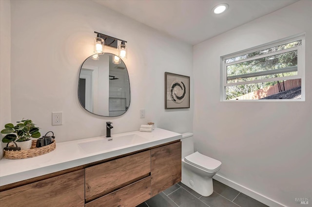 bathroom with baseboards, toilet, tile patterned floors, vanity, and recessed lighting