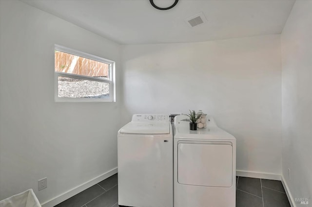 clothes washing area with laundry area, dark tile patterned floors, visible vents, and washer and clothes dryer