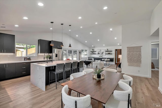 dining area featuring high vaulted ceiling, light wood-type flooring, baseboards, and recessed lighting