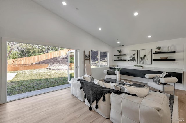 living area with high vaulted ceiling, recessed lighting, and light wood-style floors