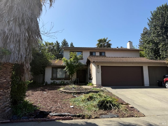 view of front of property with a tile roof, a chimney, concrete driveway, a garage, and stucco siding