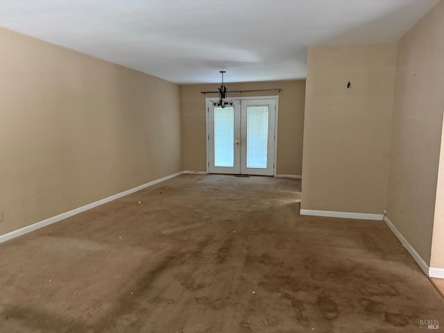carpeted empty room with french doors and baseboards