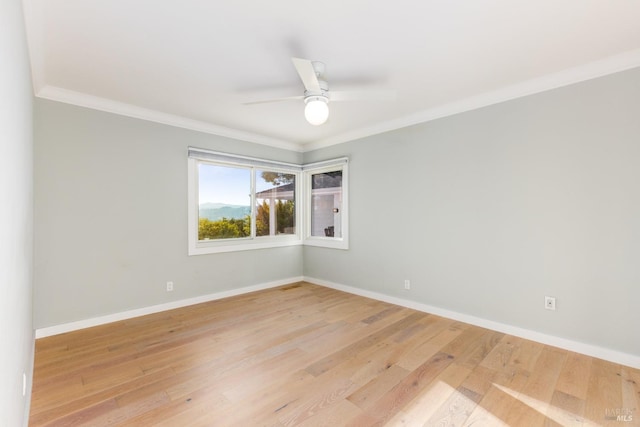 empty room featuring ornamental molding, light wood-style flooring, and baseboards