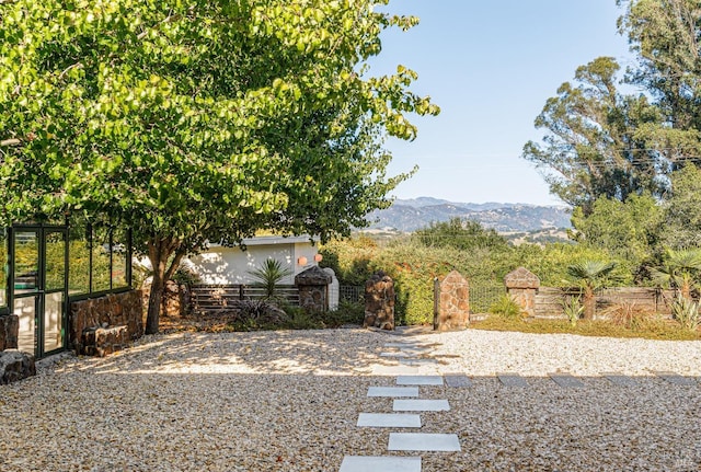 view of yard featuring fence and a mountain view