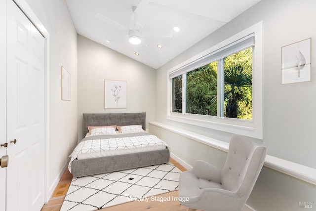 bedroom with recessed lighting, a closet, vaulted ceiling, wood finished floors, and baseboards