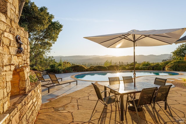 pool with a patio area and a mountain view