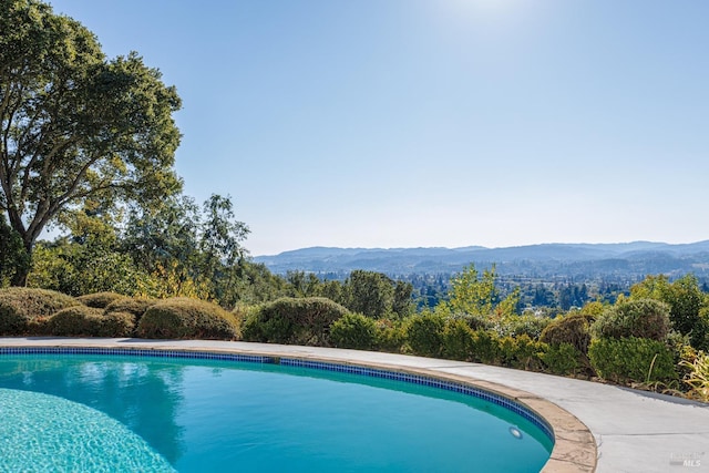 pool with a mountain view and a view of trees