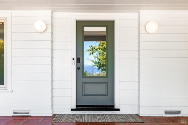 entrance to property featuring crawl space and visible vents