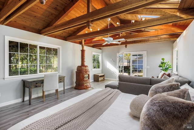 bedroom featuring multiple windows, vaulted ceiling with beams, and wood finished floors