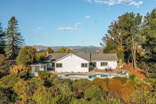 back of house featuring a patio, a mountain view, and an outdoor pool