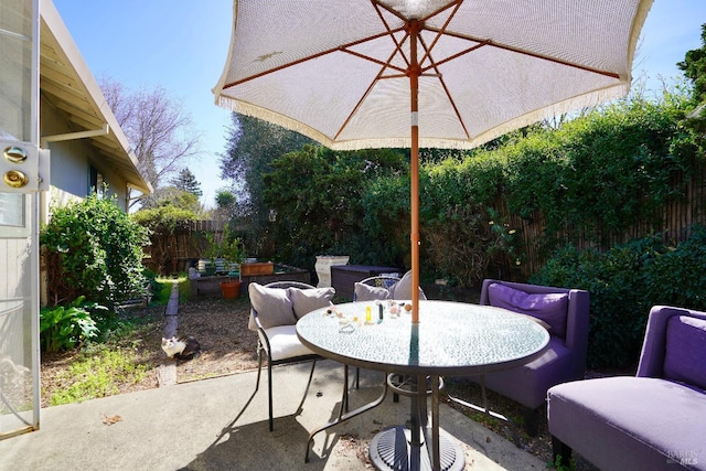 view of patio with outdoor dining area and fence