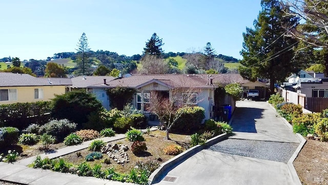 ranch-style home with concrete driveway and fence