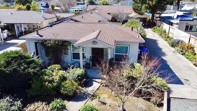 view of front of property featuring a tile roof, a residential view, and stucco siding