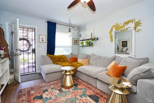 living room with a ceiling fan, visible vents, and wood finished floors