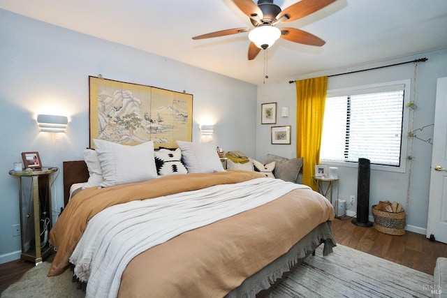 bedroom with a ceiling fan, baseboards, and wood finished floors