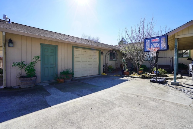 exterior space with concrete driveway, roof with shingles, and an attached garage