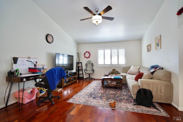 living area featuring baseboards, a ceiling fan, vaulted ceiling, and wood finished floors