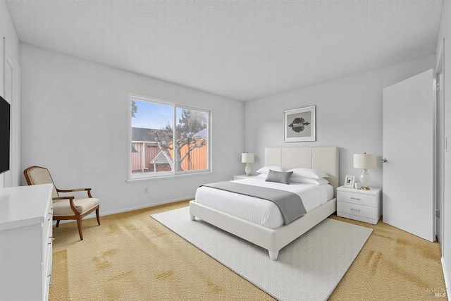 bedroom with a textured ceiling and light carpet