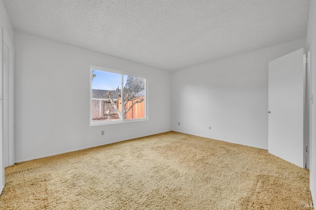 carpeted spare room featuring a textured ceiling