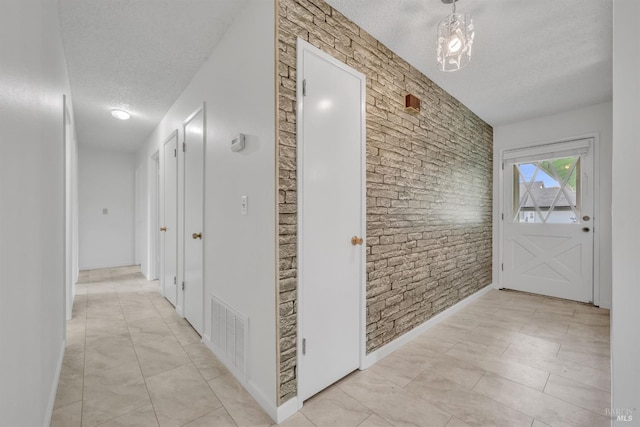 hall featuring visible vents and a textured ceiling