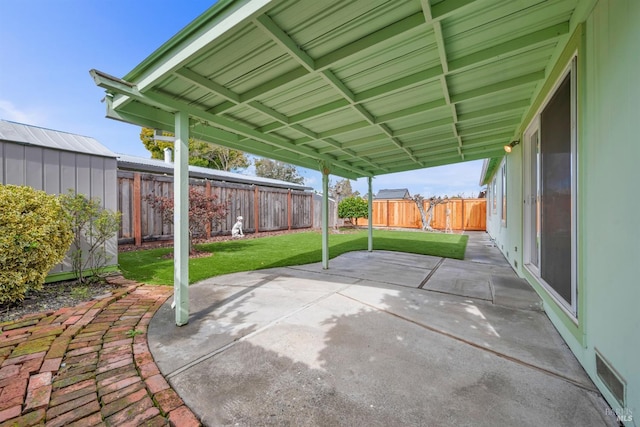 view of patio featuring an outdoor structure and a fenced backyard