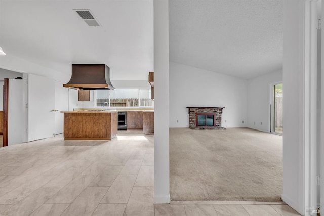 unfurnished living room featuring visible vents, beverage cooler, light colored carpet, lofted ceiling, and a sink