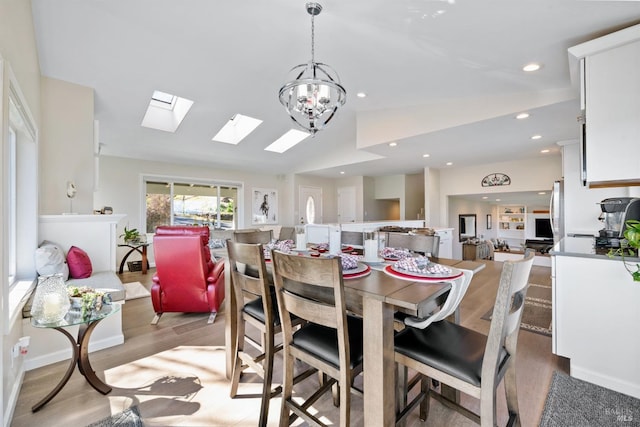 dining area with recessed lighting, vaulted ceiling, light wood-style flooring, and an inviting chandelier