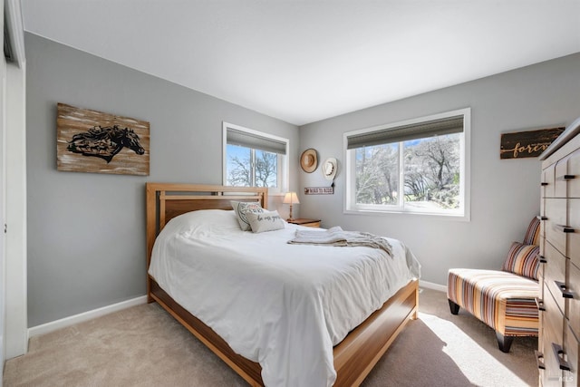 bedroom featuring light carpet and baseboards