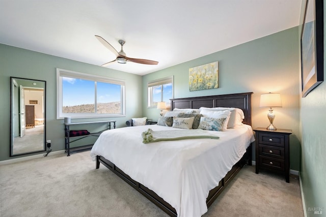 bedroom featuring baseboards, a ceiling fan, and light colored carpet