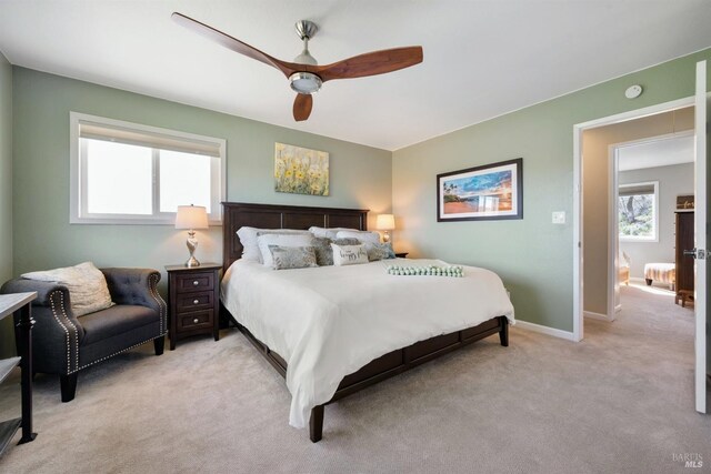 bedroom featuring baseboards, a ceiling fan, and light colored carpet