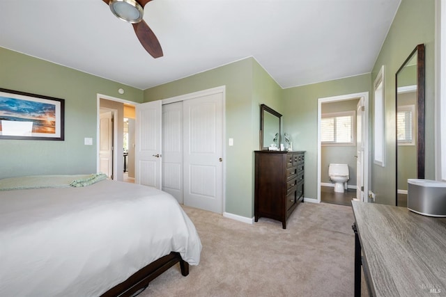 bedroom featuring light carpet, a ceiling fan, baseboards, and a closet