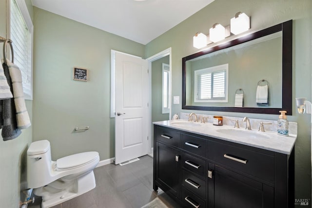 bathroom with tile patterned flooring, a sink, toilet, and double vanity