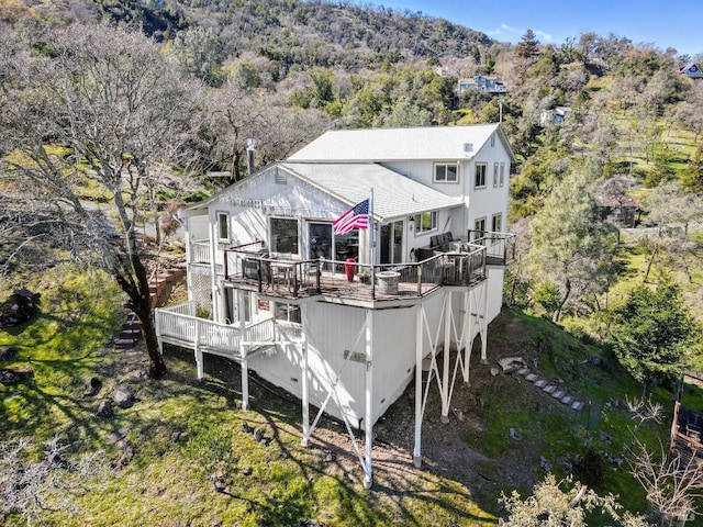 rear view of property featuring a wooden deck