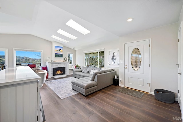 living area with dark wood-type flooring, a healthy amount of sunlight, and a fireplace with flush hearth