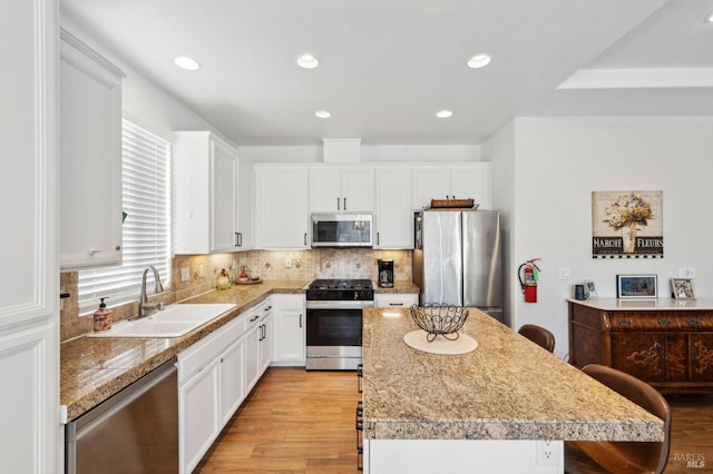 kitchen featuring tasteful backsplash, appliances with stainless steel finishes, a sink, and a center island