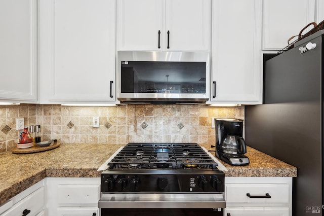 kitchen with appliances with stainless steel finishes, white cabinets, and decorative backsplash