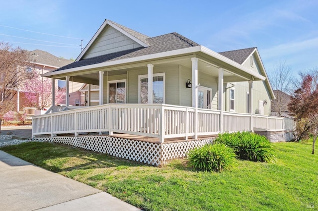 view of front of house with a porch, a front lawn, and a shingled roof