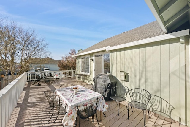 wooden terrace featuring outdoor dining space and grilling area