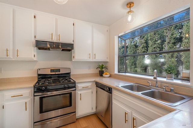 kitchen with appliances with stainless steel finishes, a sink, white cabinets, and under cabinet range hood