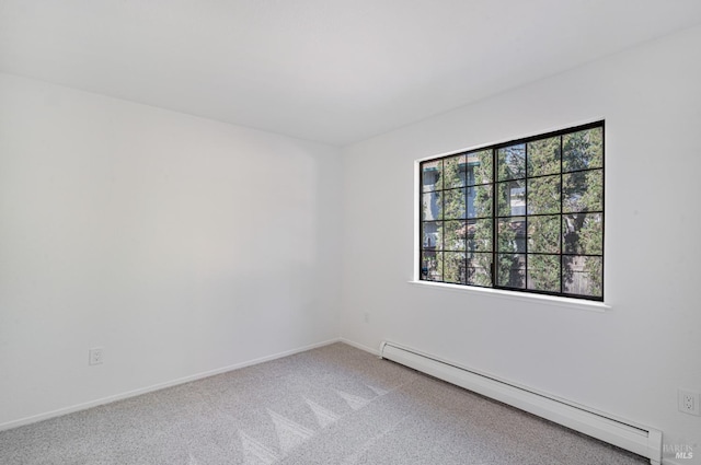 carpeted empty room with baseboards and a baseboard heating unit