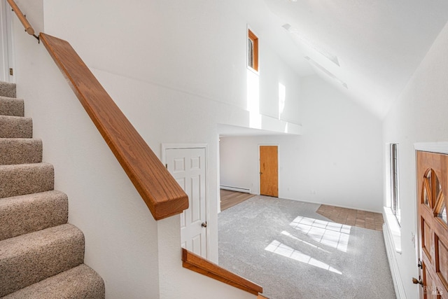 additional living space with carpet, stairs, high vaulted ceiling, and a wealth of natural light