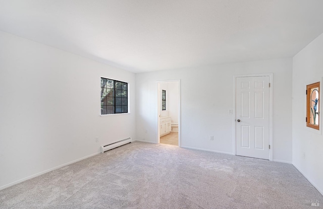 unfurnished bedroom featuring baseboards, light colored carpet, baseboard heating, and ensuite bathroom