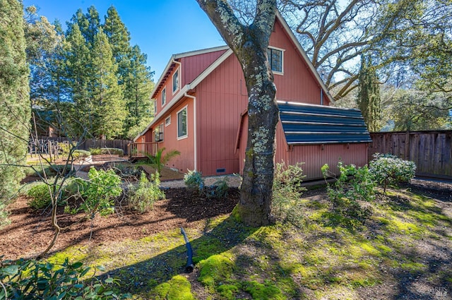 view of side of home featuring crawl space and fence