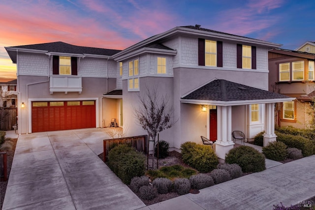 view of front facade with concrete driveway, a garage, and stucco siding