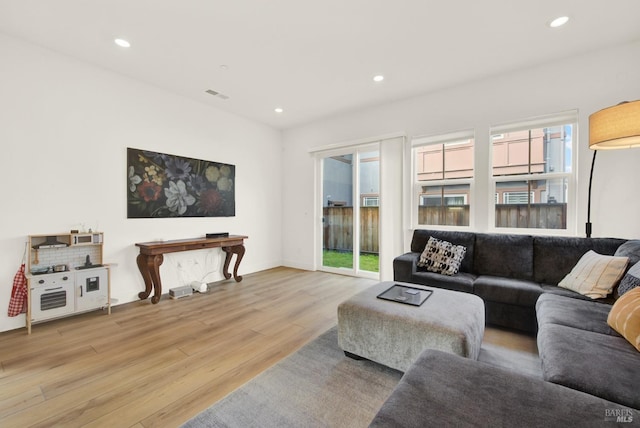 living room featuring recessed lighting, wood finished floors, and visible vents