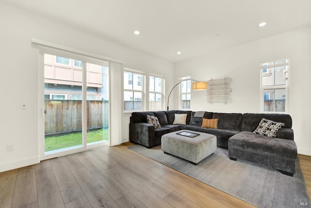 living room with plenty of natural light, wood finished floors, recessed lighting, and baseboards