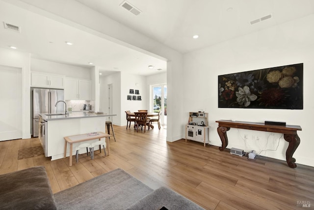 living room featuring recessed lighting, visible vents, and light wood-style flooring