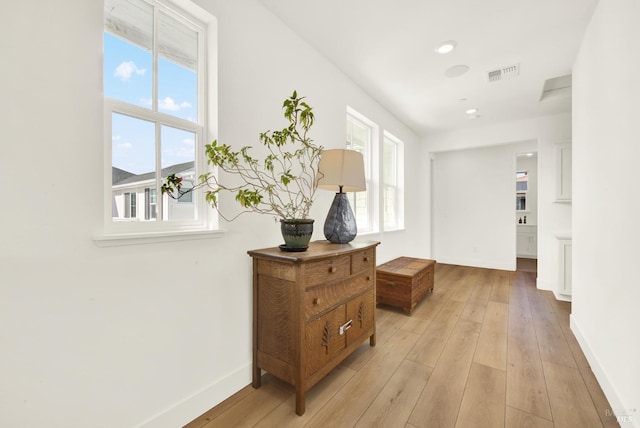 hall featuring recessed lighting, visible vents, baseboards, and light wood-style floors