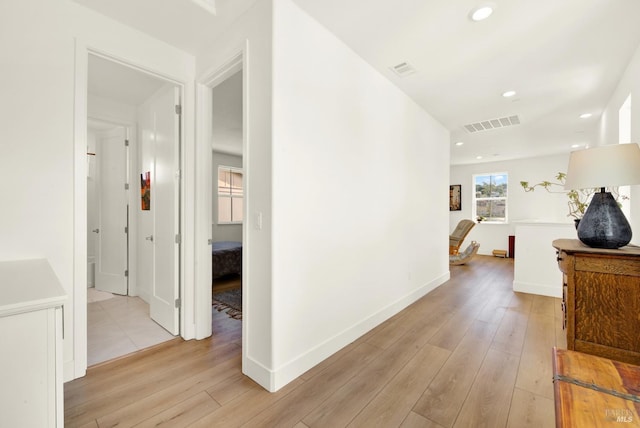 hall featuring recessed lighting, visible vents, baseboards, and light wood-style flooring